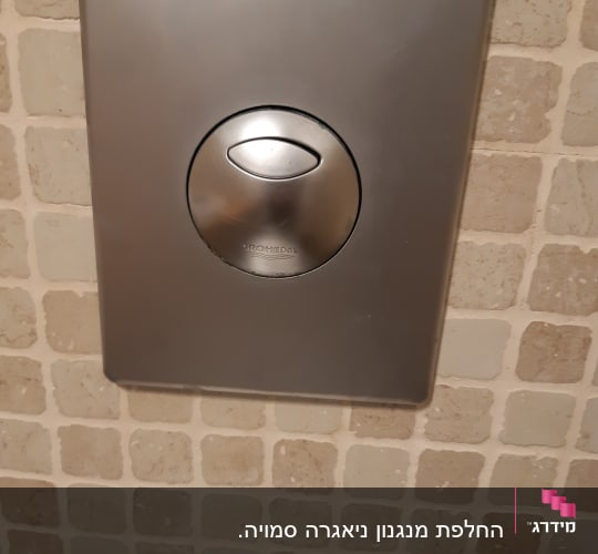 לחצן נירוסטה להדחת אסלה על קיר אריחים